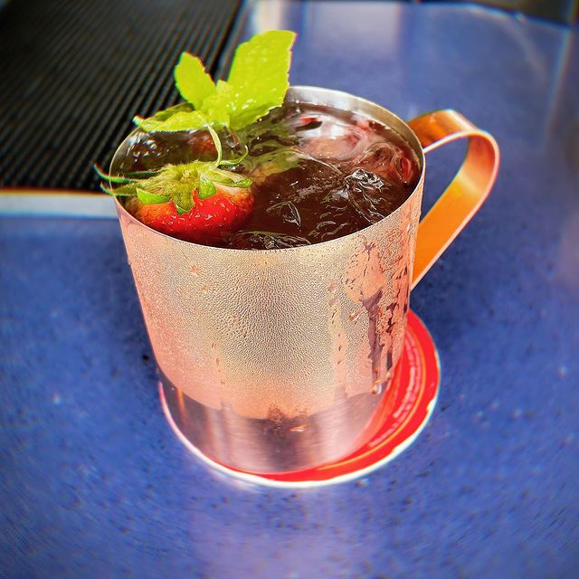 A moscow mule with strawberries and mint.